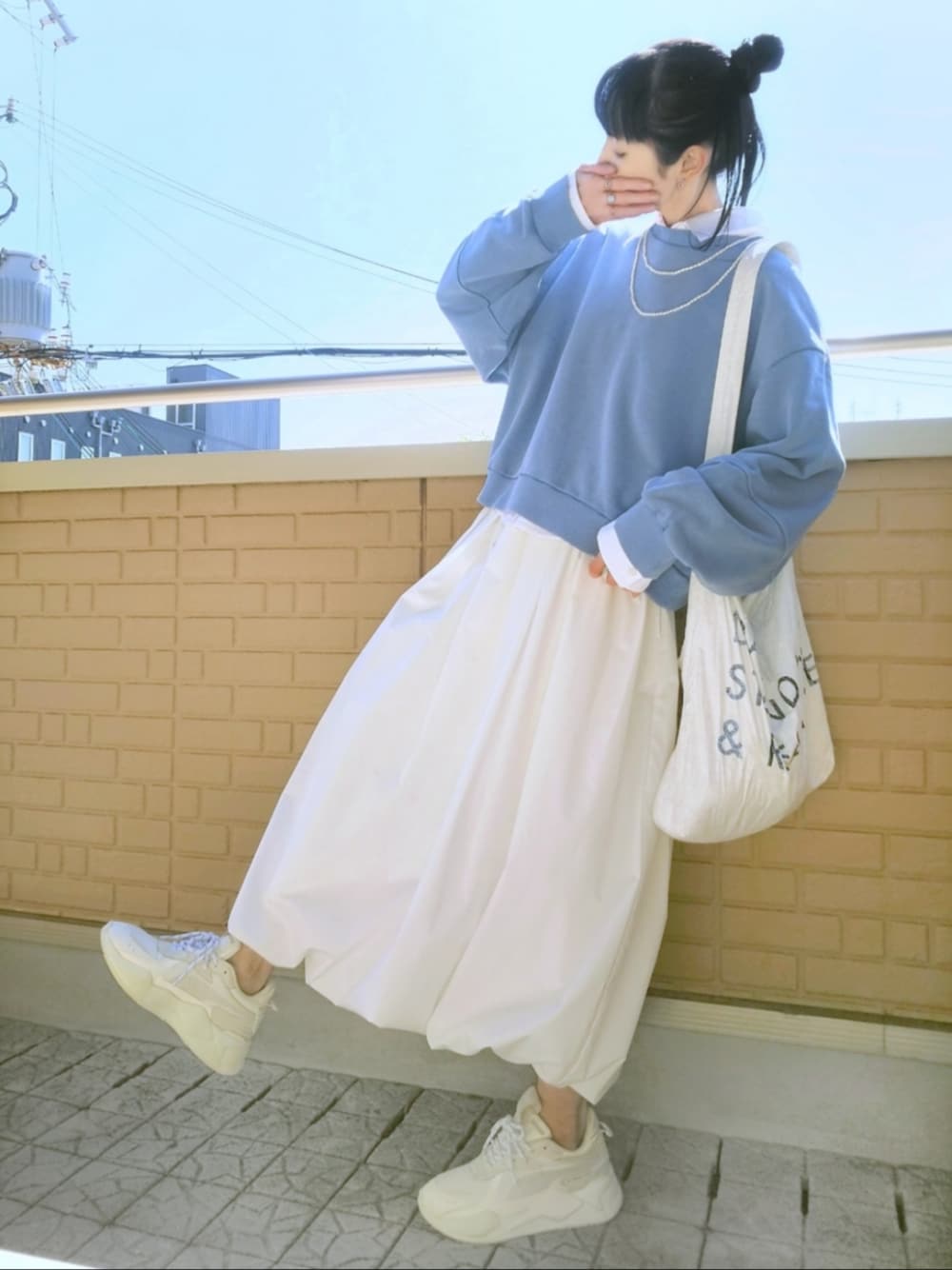 ホワイト系のスニーカー、ホワイト系のスカート、ブルー系のスウェットを着用したレディースの春コーディネートの1枚目の写真