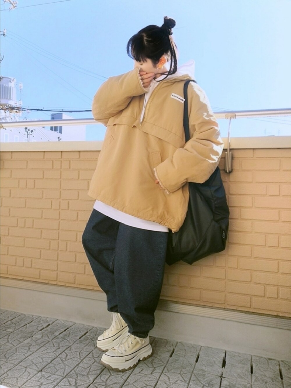 ホワイト系のスニーカー、ブルー系のデニムパンツ、ベージュ系のブルゾンを着用したレディースの冬コーディネートの1枚目の写真