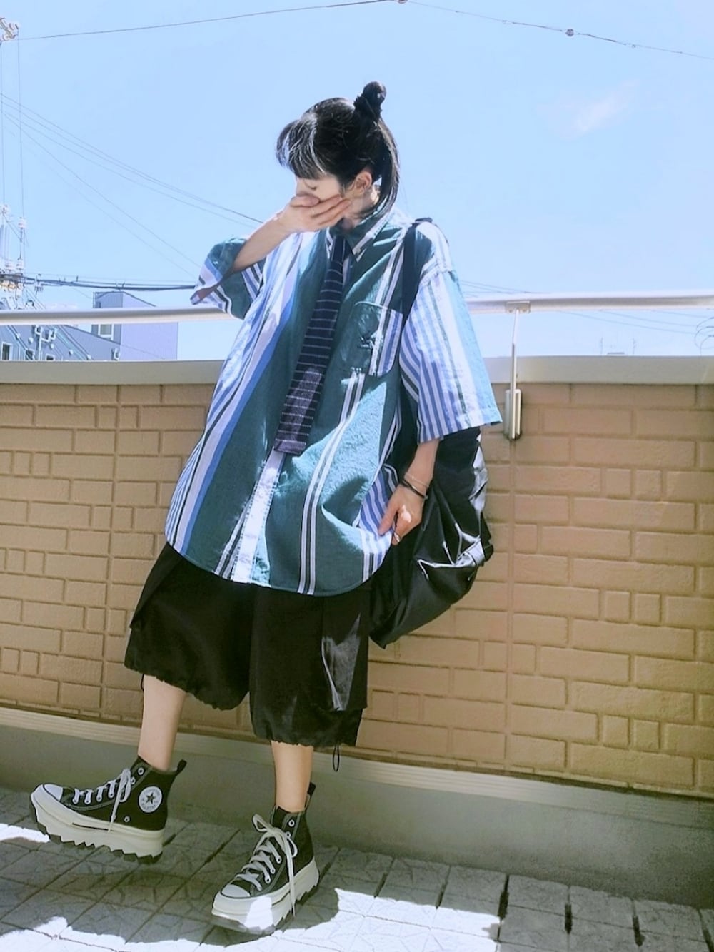 ブラック系のスニーカー、ブラック系のカーゴパンツ、ブラック系のトートバッグを着用したレディースの夏コーディネートの1枚目の写真