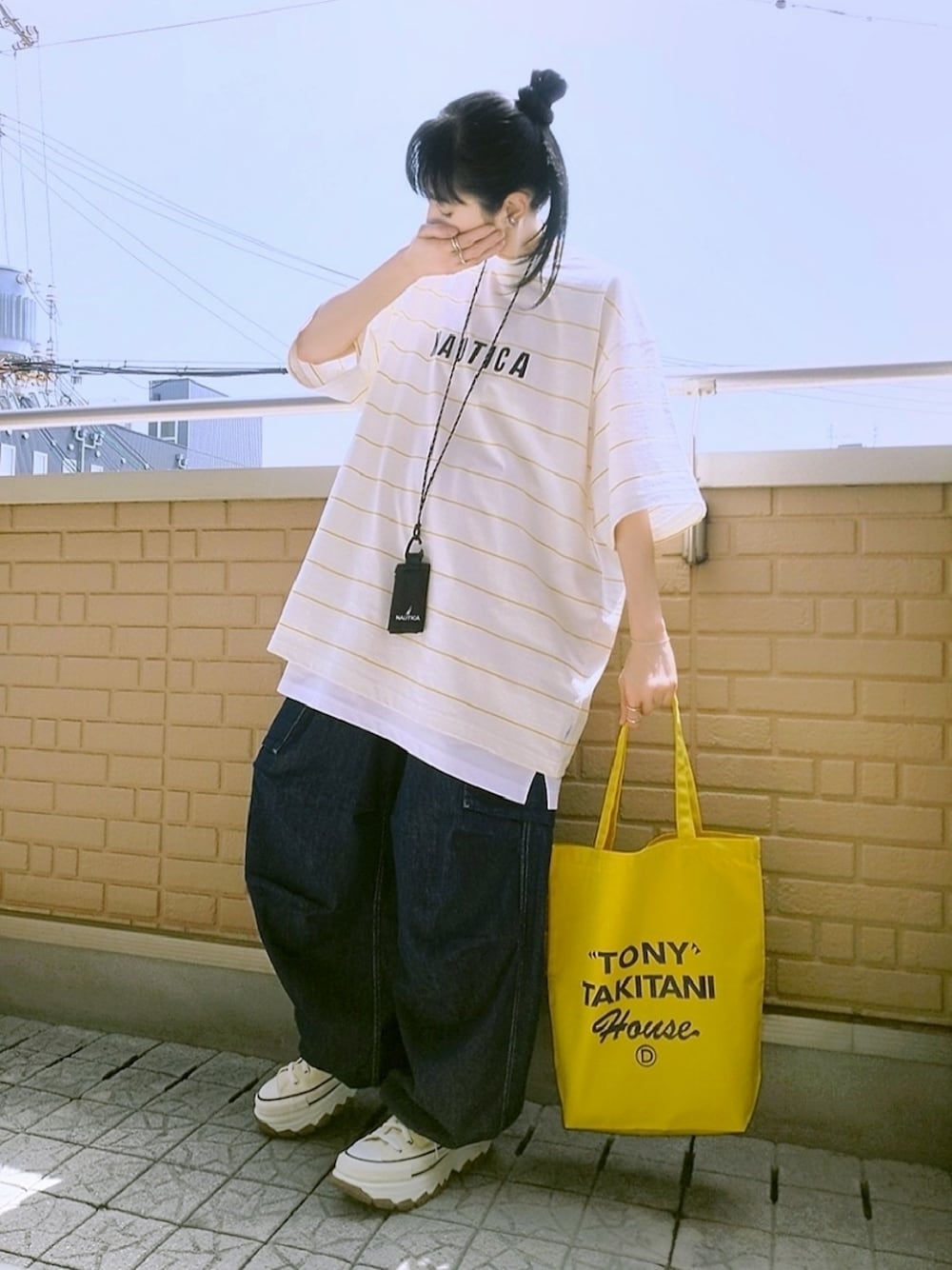 ホワイト系のスニーカー、ブルー系のデニムパンツ、イエロー系のTシャツ/カットソーを着用したレディースの春コーディネートの1枚目の写真