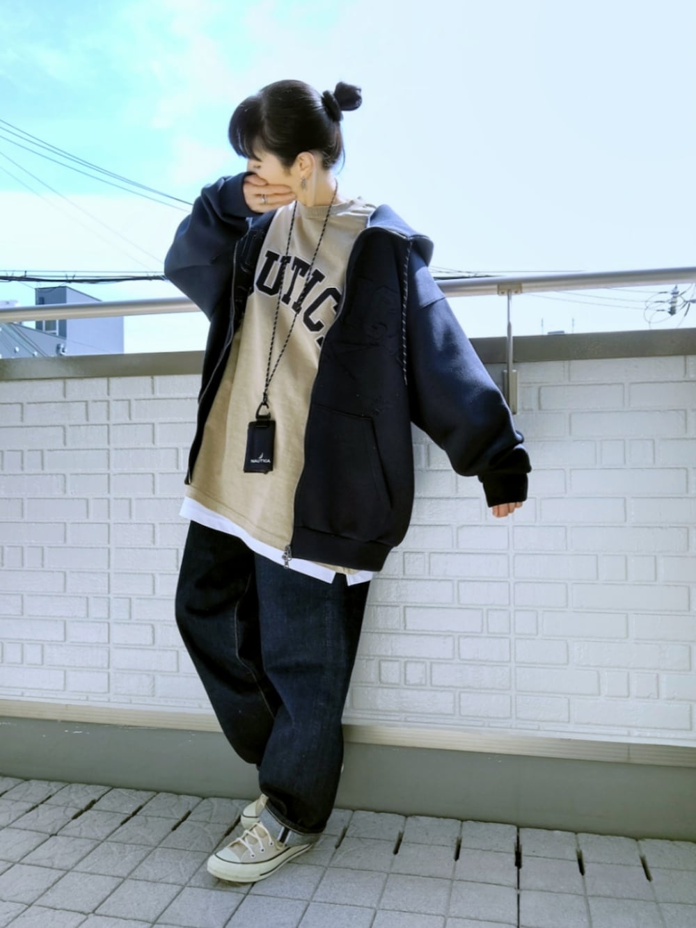 ベージュ系のスニーカー、ブルー系のデニムパンツ、ブルー系のパーカーを着用したレディースの春コーディネートの1枚目の写真