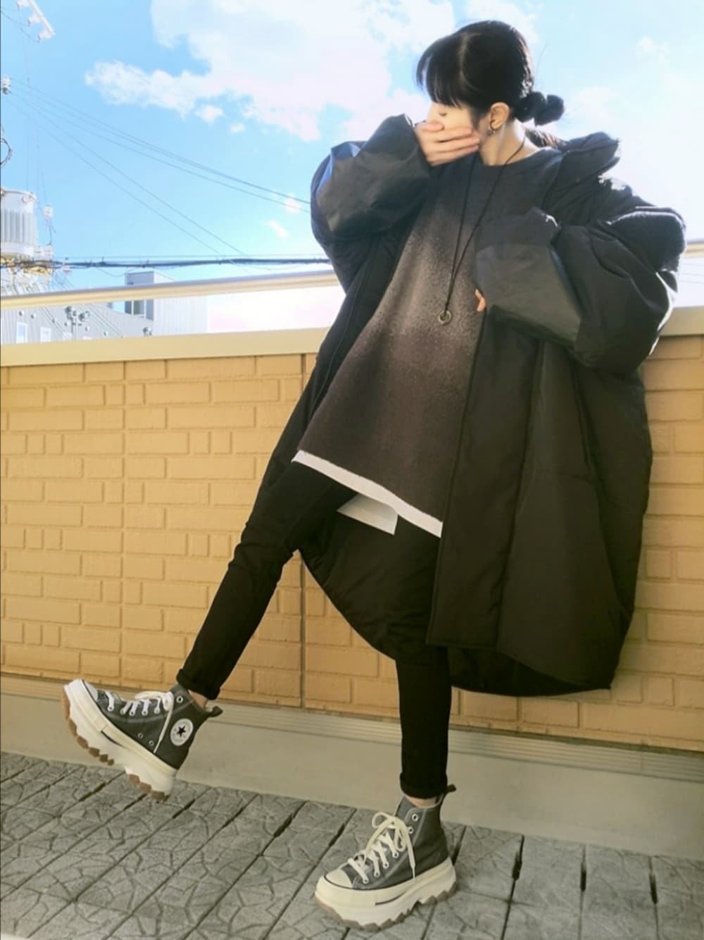 グレー系のスニーカー、ブラック系のデニムパンツ、ブラック系のミリタリージャケットを着用したレディースの秋コーディネートの1枚目の写真