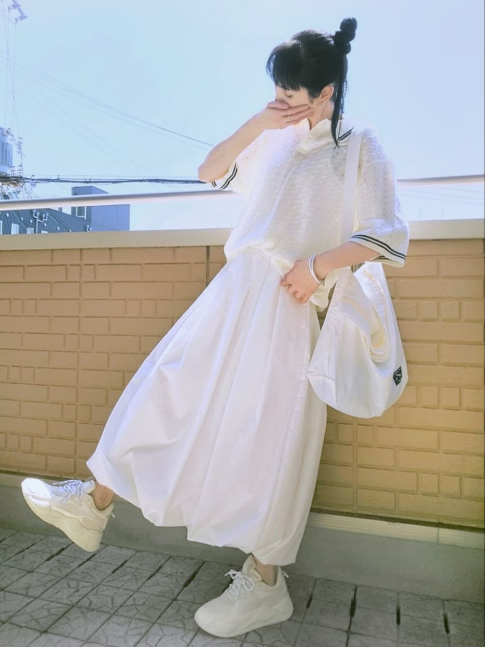ホワイト系のスニーカー、ホワイト系のスカート、ホワイト系のショルダーバッグを着用したレディースの春コーディネートの1枚目の写真