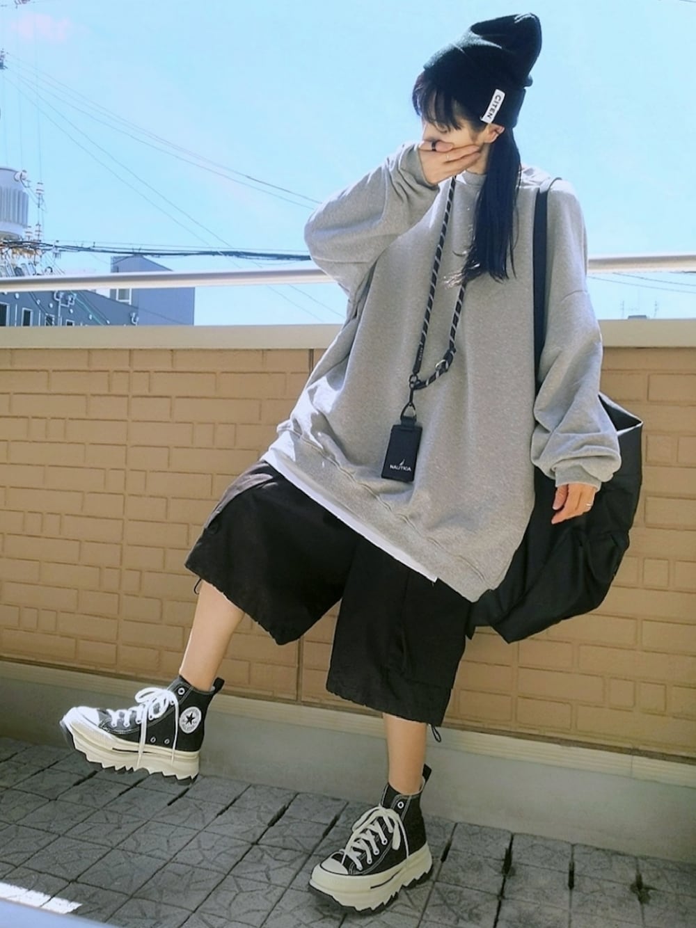 ブラック系のスニーカー、ブラック系のカーゴパンツ、グレー系のスウェットを着用したレディースの秋コーディネートの1枚目の写真