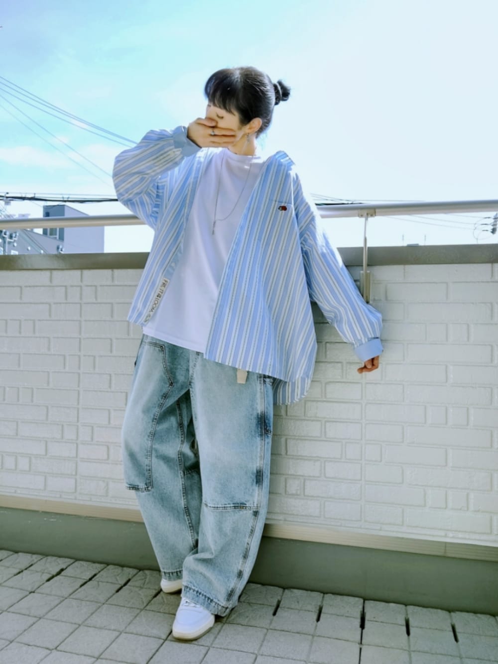 ホワイト系のスニーカー、ブルー系のデニムパンツ、ホワイト系のシャツ/ブラウスを着用したレディースの春コーディネートの1枚目の写真