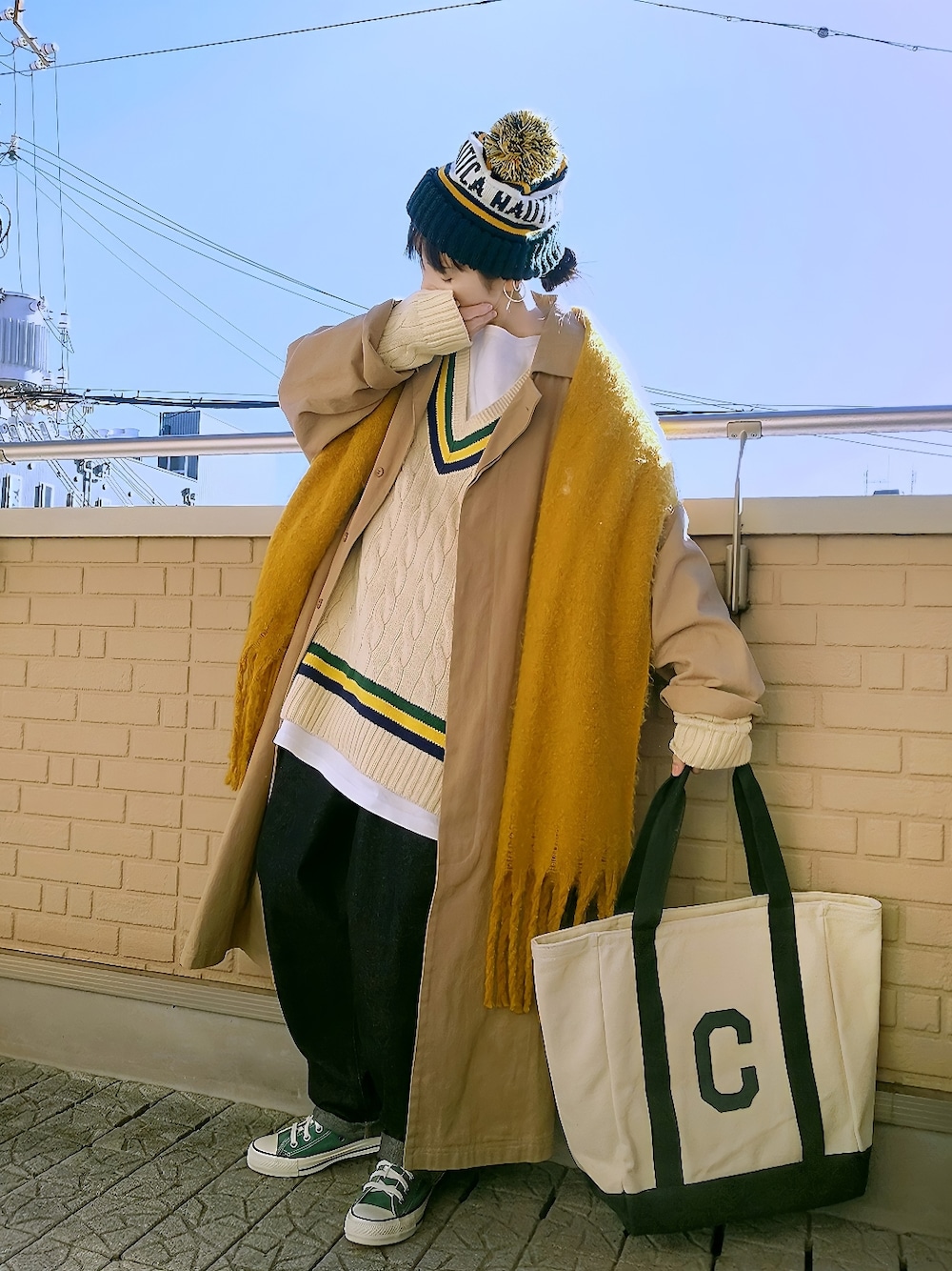 ホワイト系のニット/セーター、ベージュ系のチェスターコート、グリーン系のトートバッグを着用したレディースの冬コーディネートの2枚目の写真