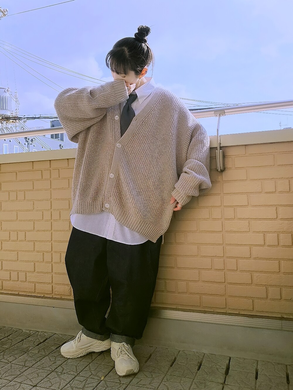 グレー系のカーディガン/ボレロ、ブルー系のデニムパンツ、ベージュ系のスニーカーを着用したレディースの冬コーディネートの2枚目の写真