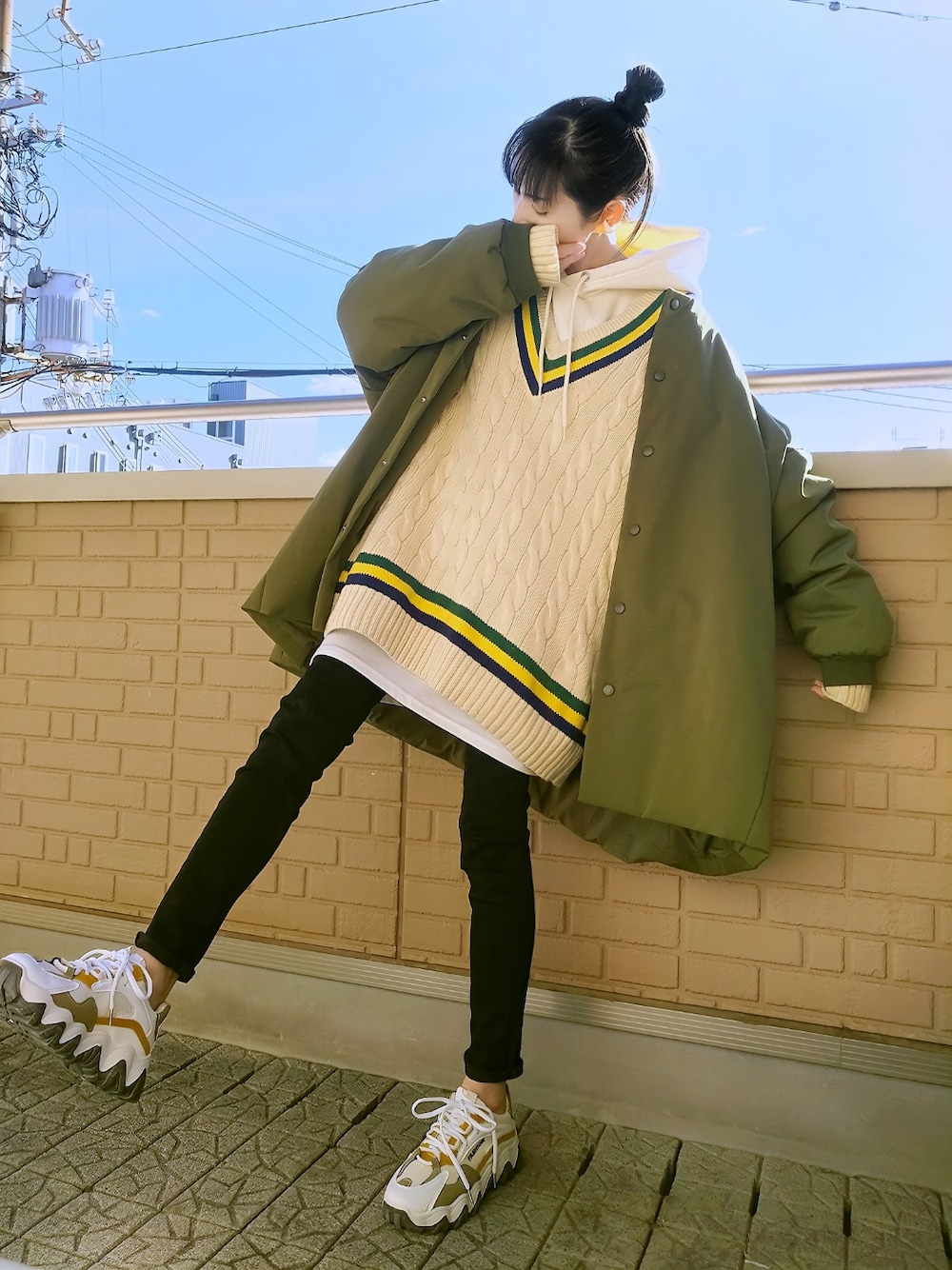 グリーン系のMA-1、ホワイト系のニット/セーター、ホワイト系のパーカーを着用したレディースの冬コーディネートの1枚目の写真