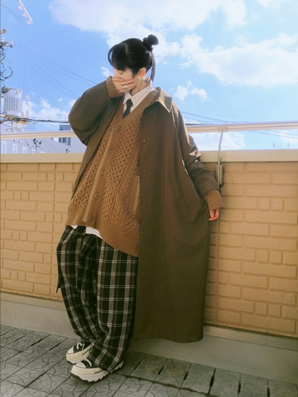 ブラック系のスニーカー、ブラック系のその他パンツ、ブラウン系のステンカラーコートを着用したレディースの冬コーディネートの1枚目の写真