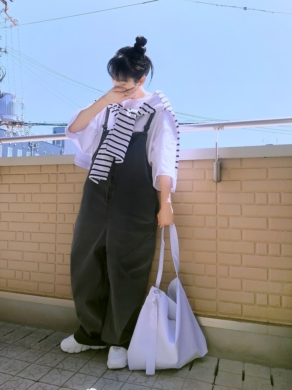 ホワイト系のTシャツ/カットソー、ブラック系のサロペット/オーバーオール、ホワイト系のショルダーバッグを着用したレディースの春コーディネートの1枚目の写真