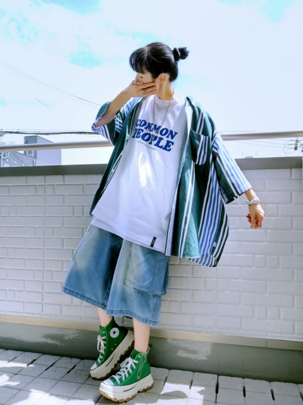 グリーン系のスニーカー、ブルー系のカーゴパンツ、ホワイト系のトートバッグを着用したレディースの夏コーディネートの1枚目の写真