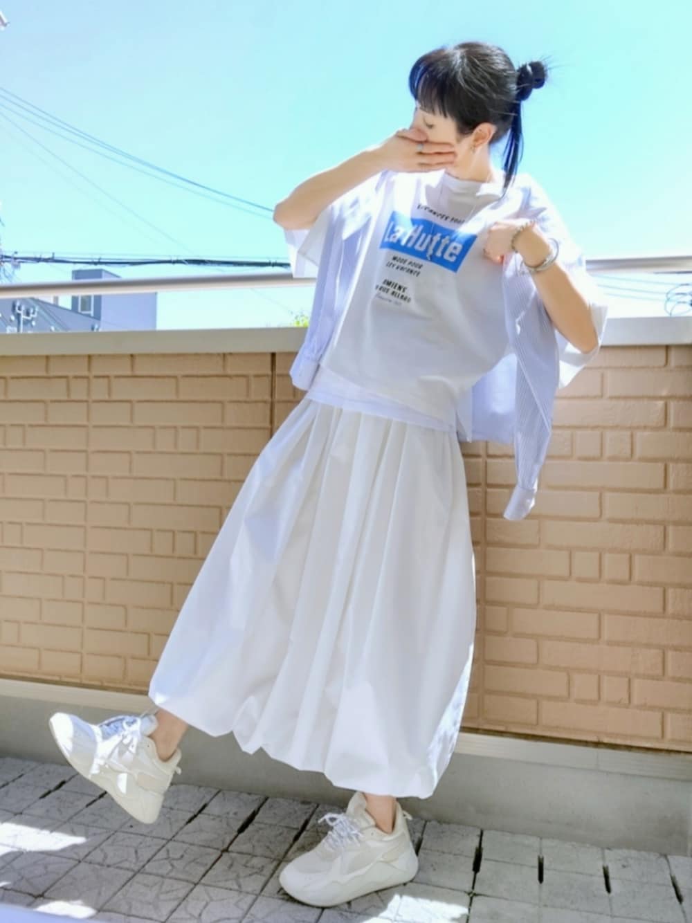 ホワイト系のスニーカー、ホワイト系のスカート、ブルー系のシャツ/ブラウスを着用したレディースの春コーディネートの1枚目の写真