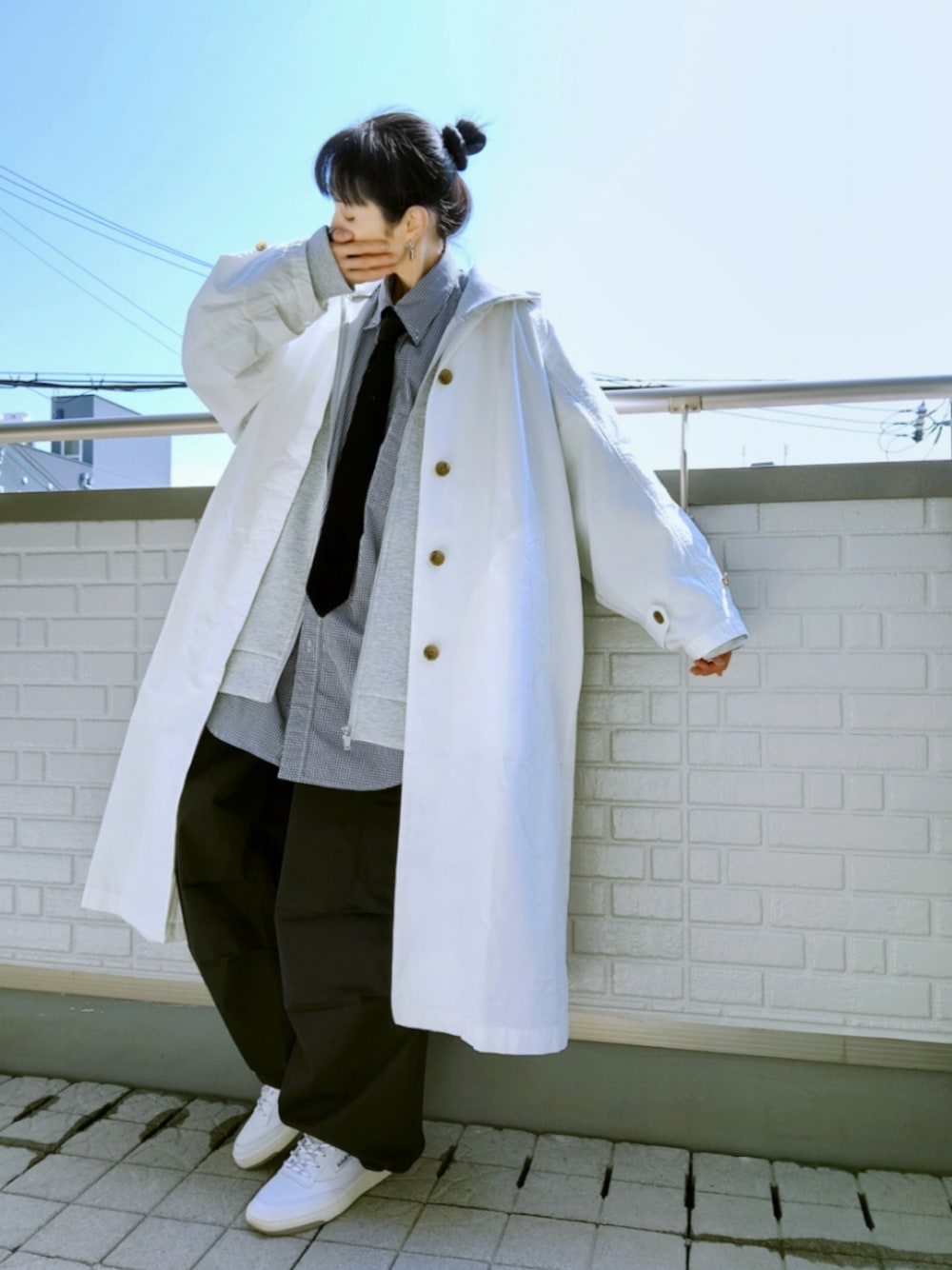 ホワイト系のスニーカー、ブラック系のカーゴパンツ、ホワイト系のステンカラーコートを着用したレディースの春コーディネートの1枚目の写真
