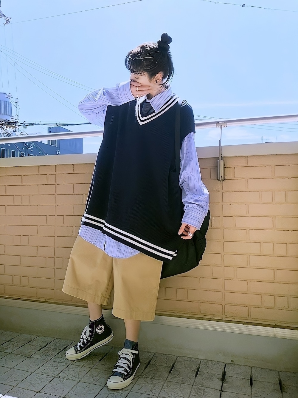 ブルー系のベスト、ブルー系のシャツ/ブラウス、ベージュ系のチノパンツを着用したレディースの秋コーディネートの1枚目の写真