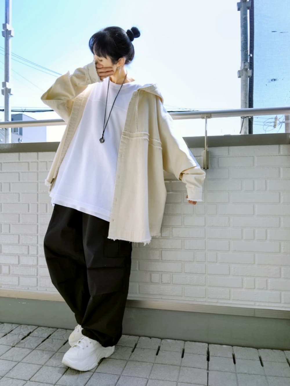 ホワイト系のスニーカー、ブラック系のカーゴパンツ、ホワイト系のシャツ/ブラウスを着用したレディースの春コーディネートの1枚目の写真