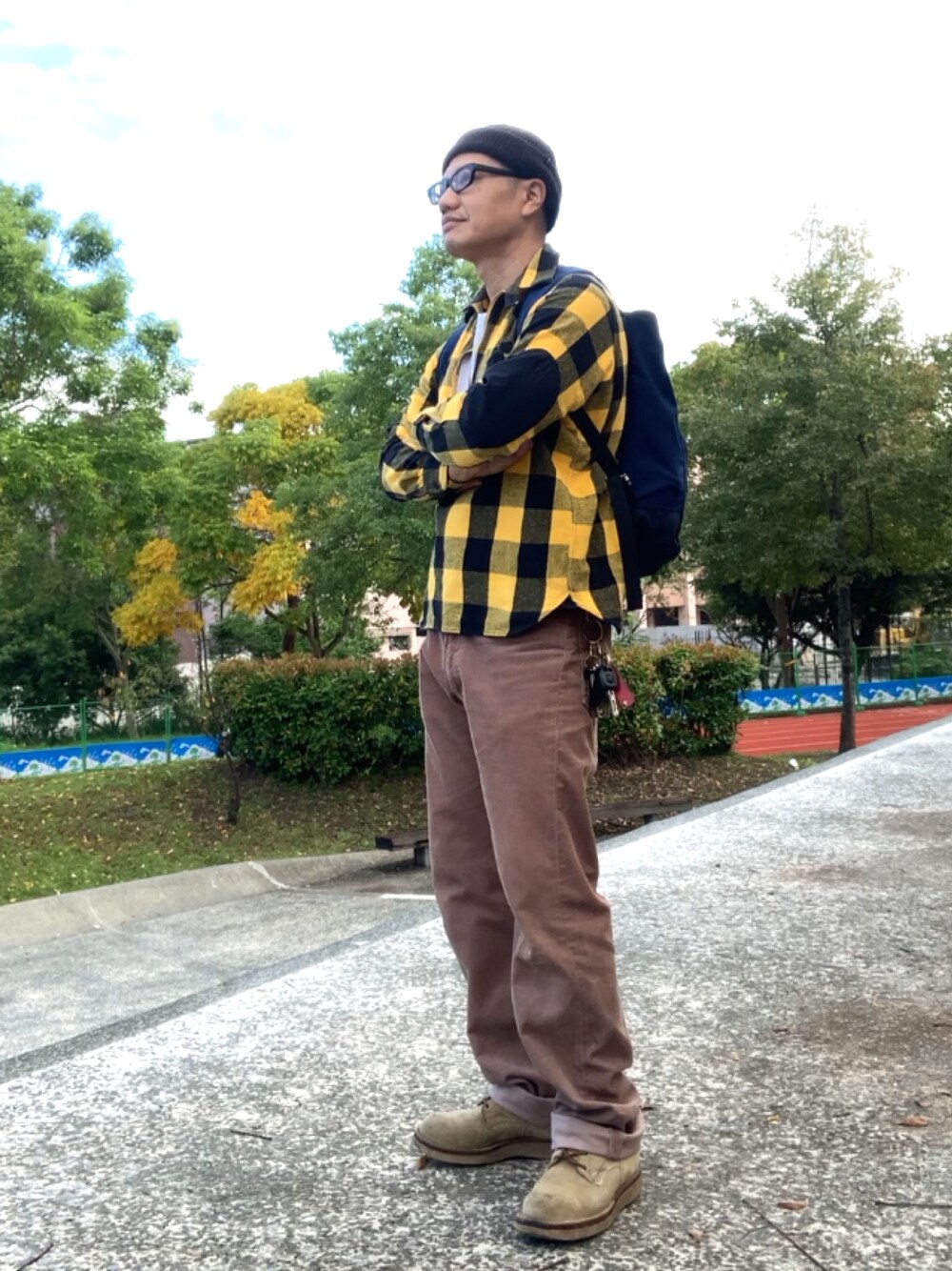 ブルー系のバックパック/リュック、イエロー系のシャツ/ブラウス、ベージュ系のブーツを着用したメンズの秋コーディネートの1枚目の写真