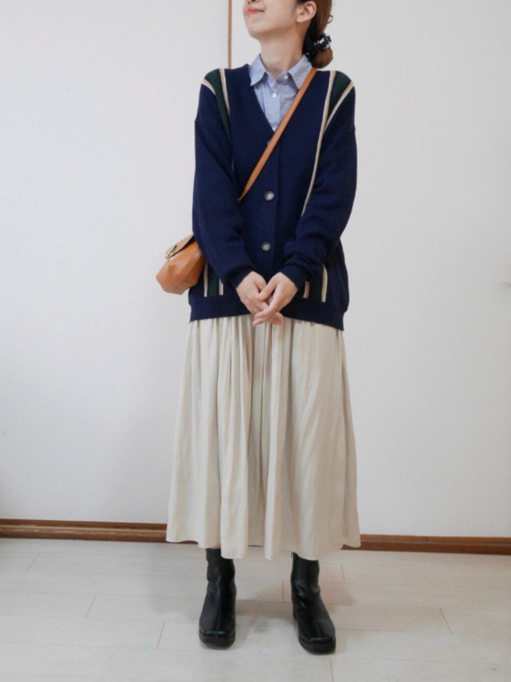 ベージュ系のスカート、ブルー系のカーディガン/ボレロ、ブルー系のシャツ/ブラウスを着用したレディースの春コーディネートの1枚目の写真