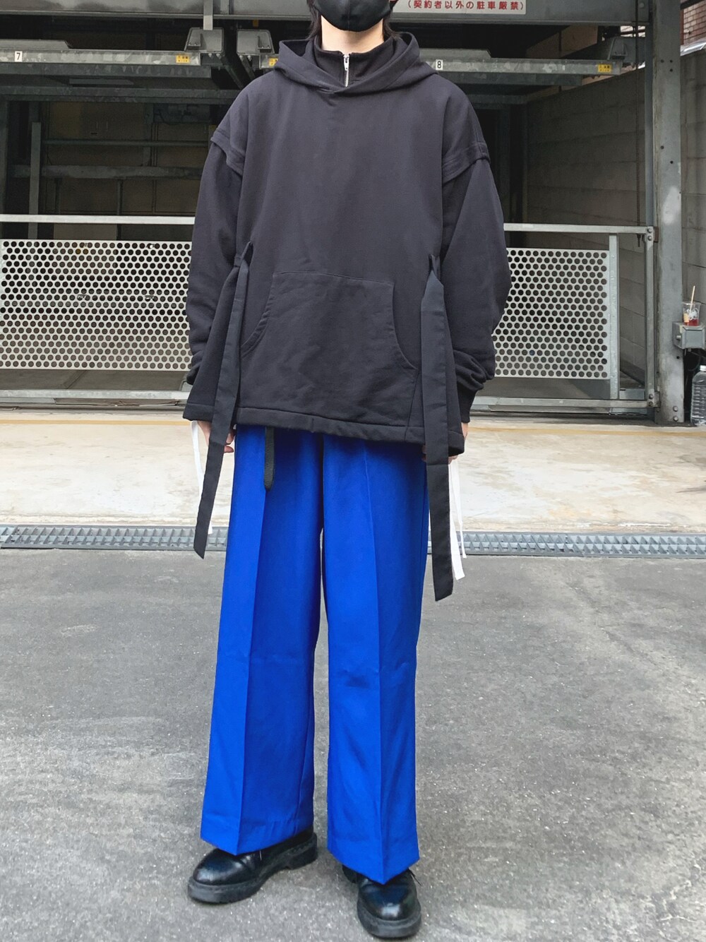 ブルー系のスラックス、ブラック系のブーツ、ブラック系のパーカーを着用したメンズの冬コーディネートの1枚目の写真