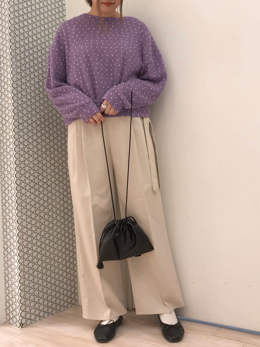 パープル系のニット/セーター、ベージュ系のその他パンツ、ブラック系のショルダーバッグを着用したレディースの春コーディネートの1枚目の写真