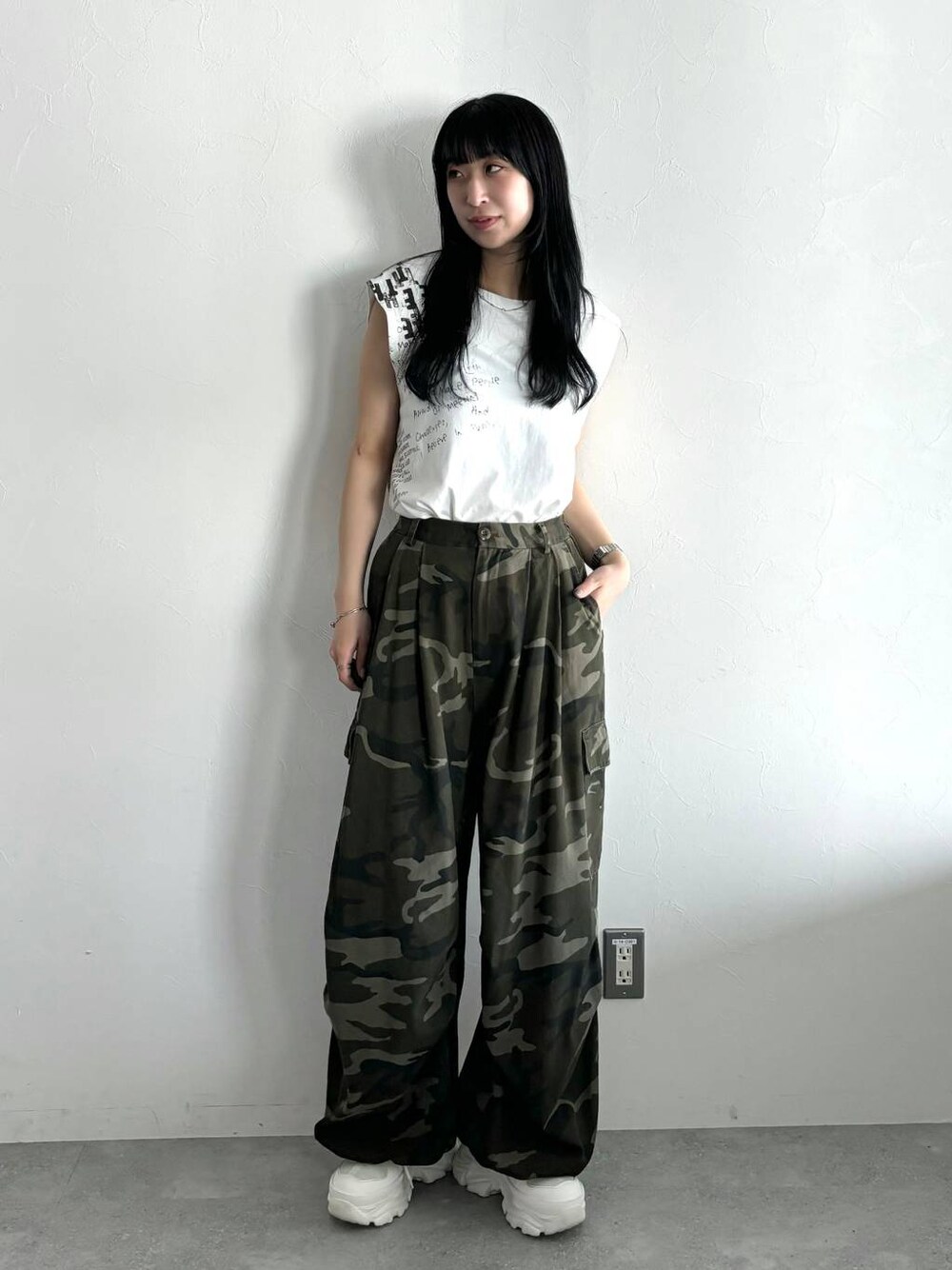 ホワイト系のスニーカー、ホワイト系のTシャツ/カットソー、グリーン系のカーゴパンツを着用したレディースの春コーディネートの1枚目の写真