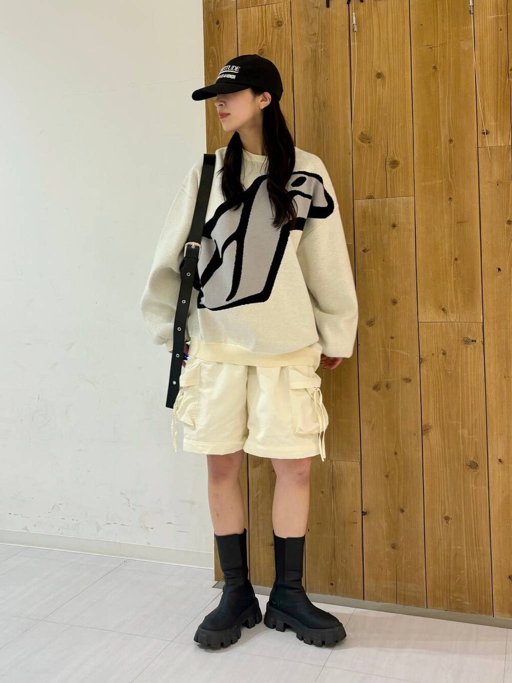ホワイト系のカーゴパンツ、ブラック系のブーツ、ブラック系のショルダーバッグを着用したレディースの冬コーディネートの1枚目の写真