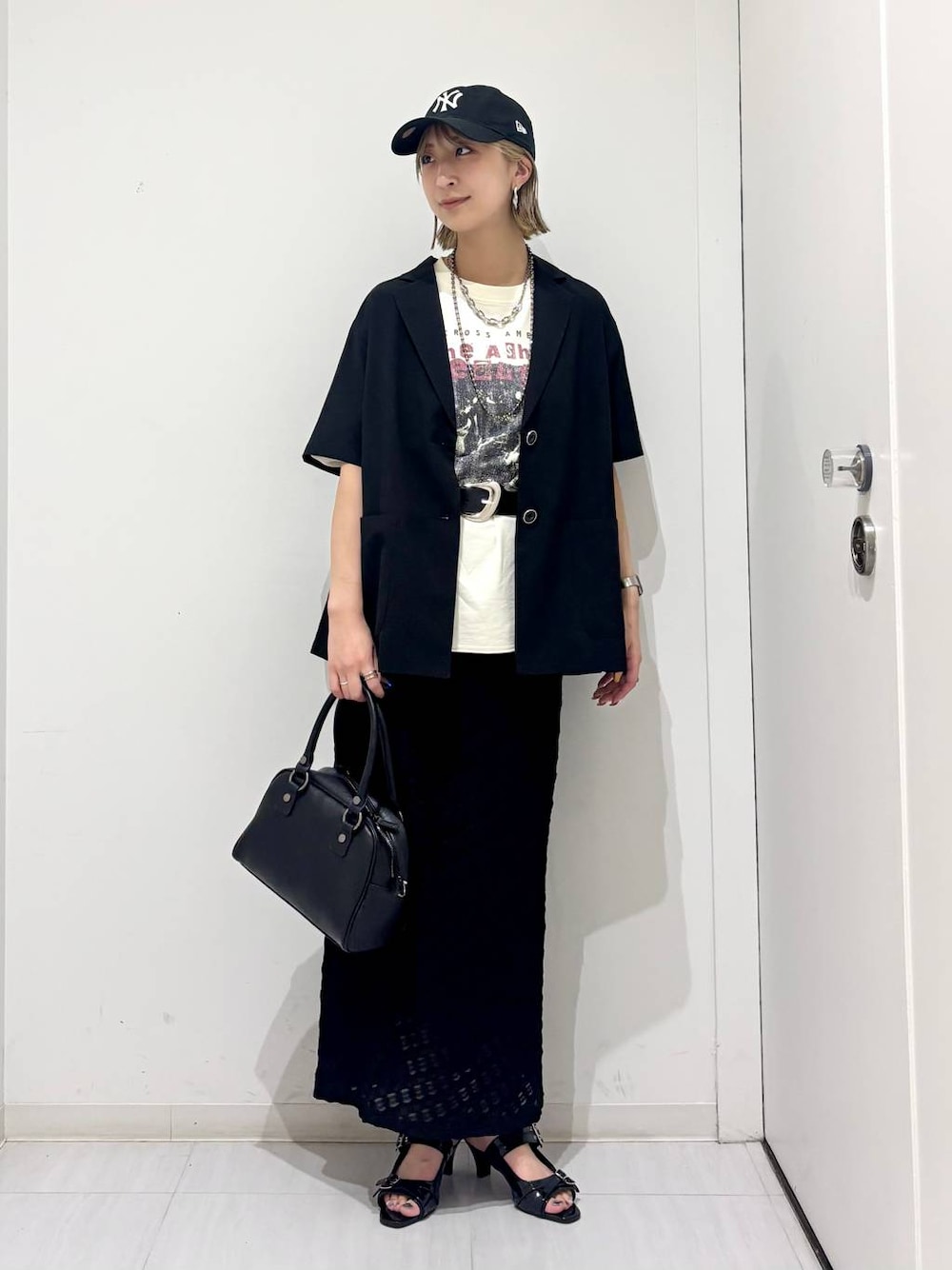 ブラック系のサンダル、ブラック系のショルダーバッグ、ブラック系のテーラードジャケットを着用したレディースの夏コーディネートの1枚目の写真