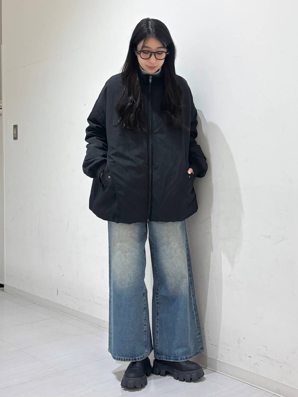 ブラック系のMA-1、ブルー系のデニムパンツを着用したレディースの冬コーディネートの1枚目の写真