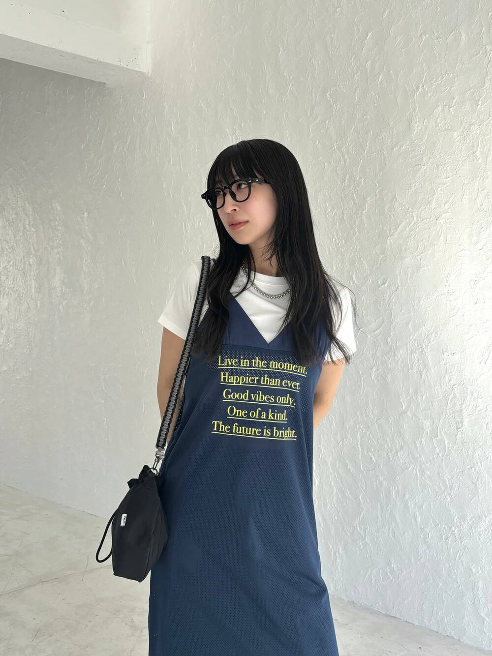 ブルー系のワンピース、ブラック系のショルダーバッグを着用したレディースの春コーディネートの1枚目の写真