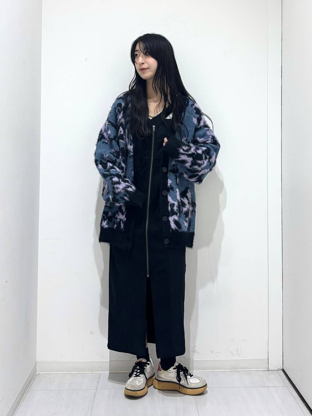 ブルー系のニット/セーター、ホワイト系のTシャツ/カットソー、ブラック系のワンピースを着用したレディースの秋コーディネートの1枚目の写真