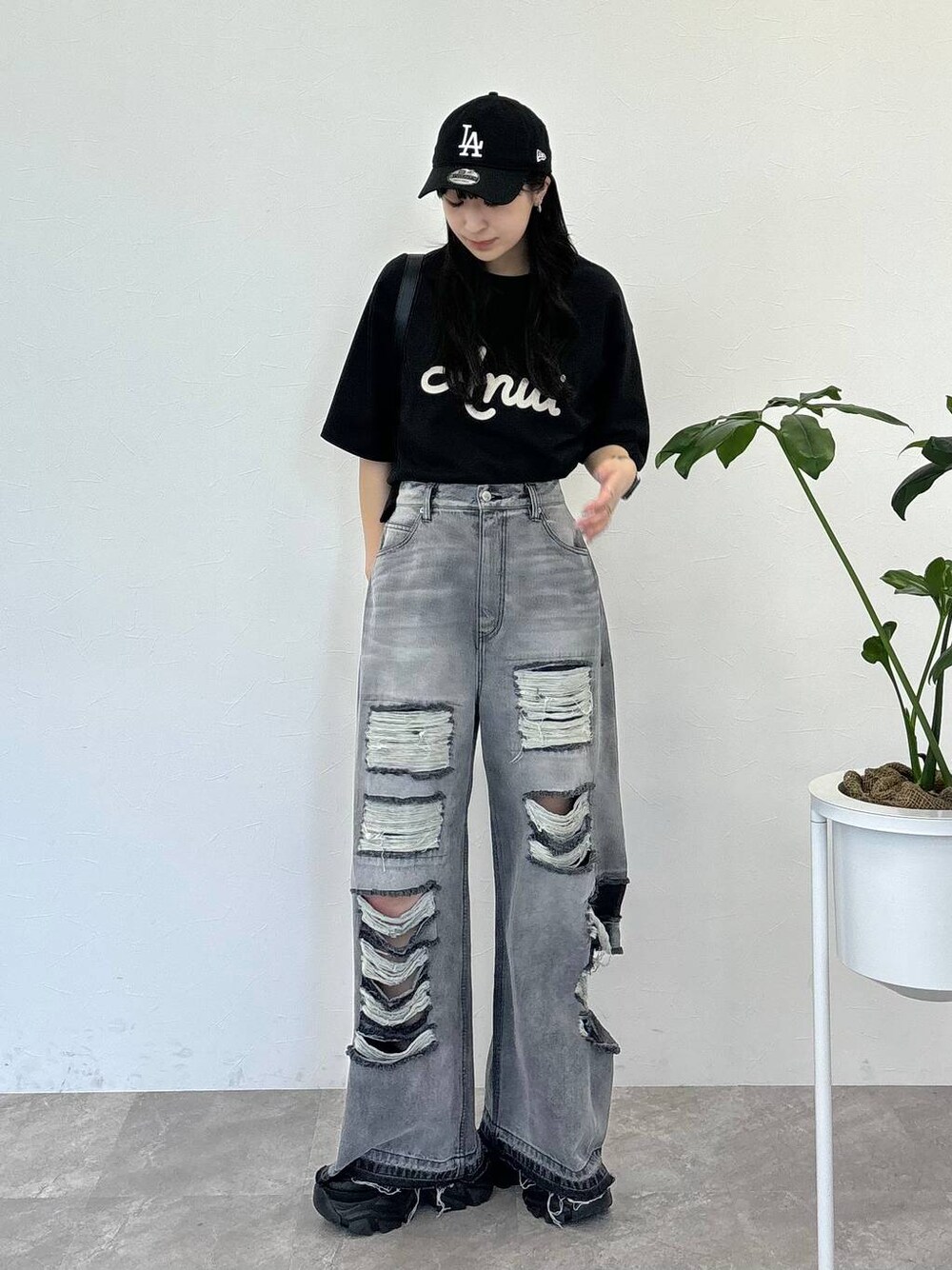 ブラック系のデニムパンツ、ブラック系のスニーカー、ブラック系のTシャツ/カットソーを着用したレディースの春コーディネートの1枚目の写真