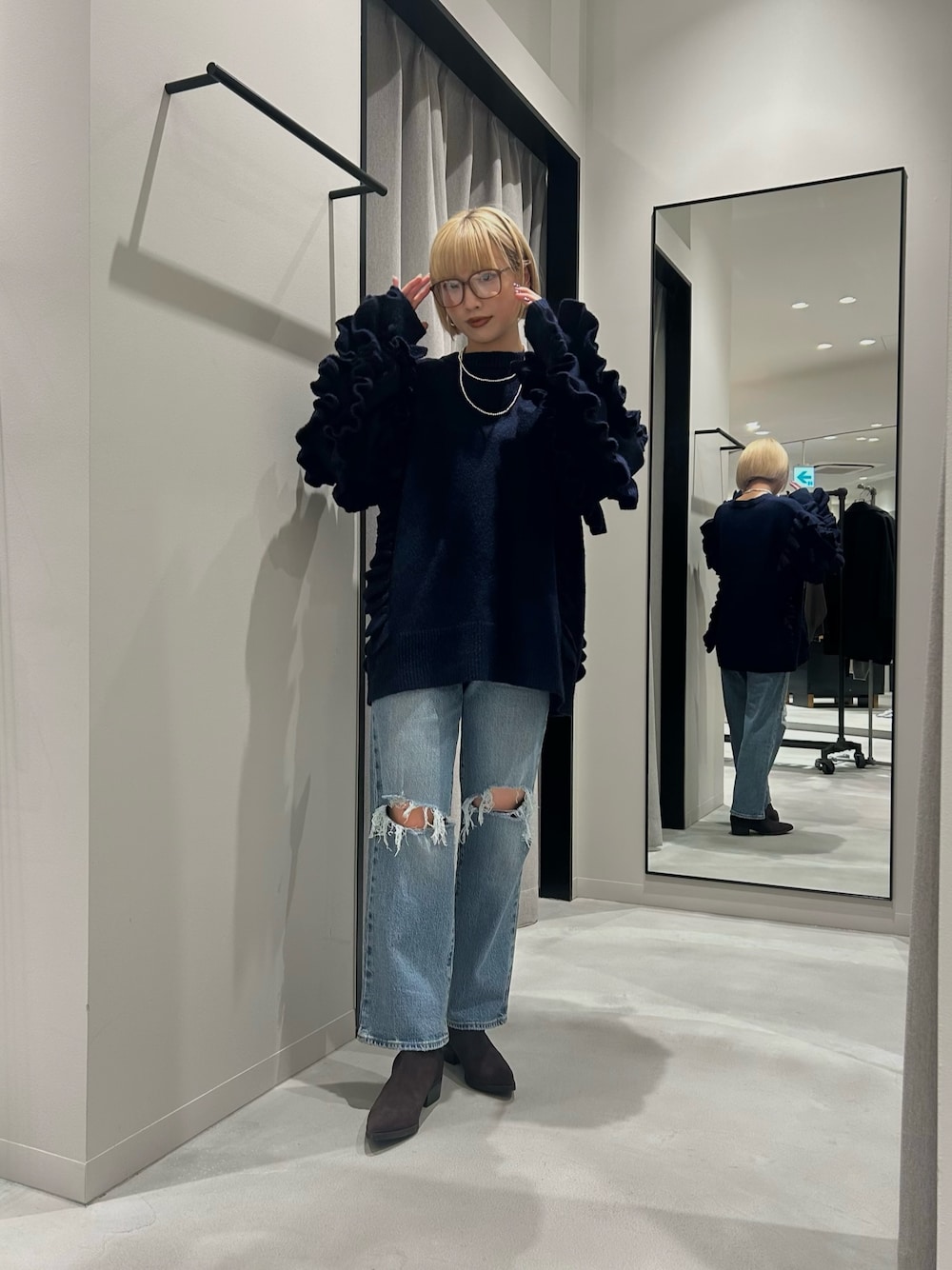 ブラック系のニット/セーター、ブルー系のデニムパンツ、ベージュ系のブーツを着用したレディースの秋コーディネートの1枚目の写真