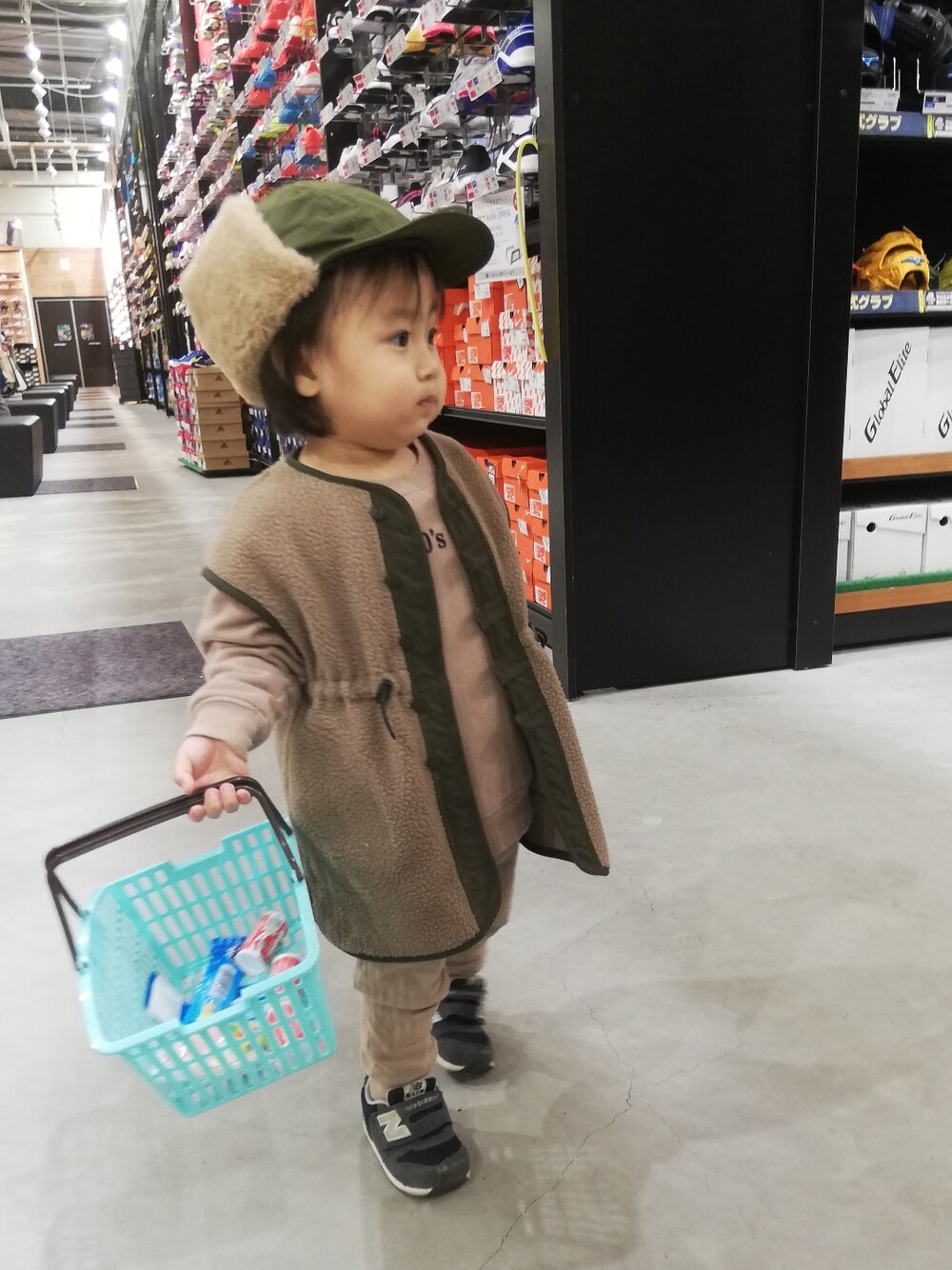 ブラウン系のベスト、ブラウン系のスウェット、ブルー系のスニーカーを着用したキッズの冬コーディネートの4枚目の写真