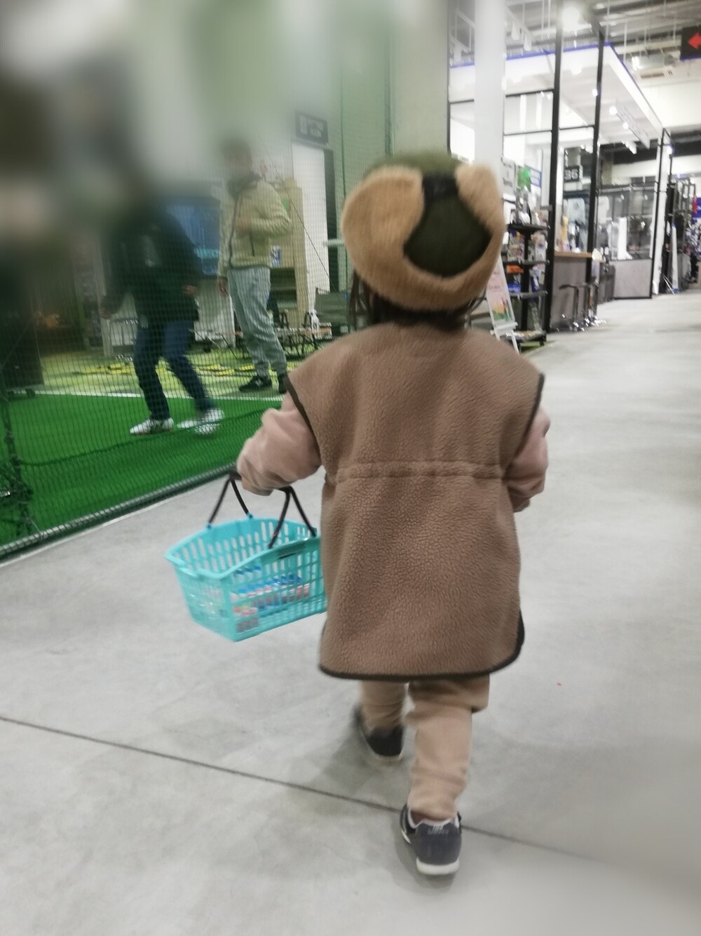 ブラウン系のベスト、ブラウン系のスウェット、ブルー系のスニーカーを着用したキッズの冬コーディネートの5枚目の写真