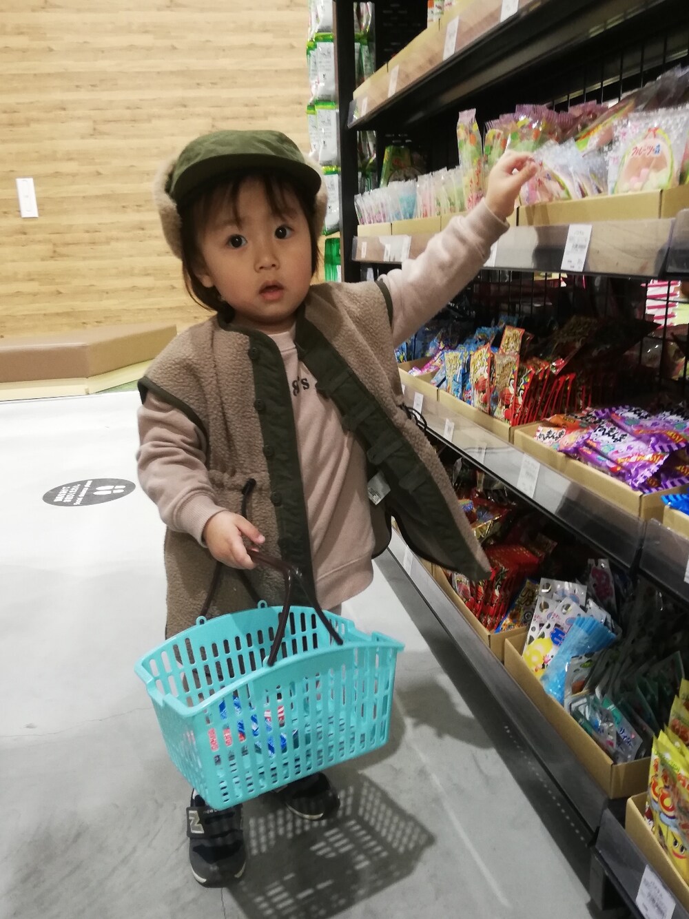 ブラウン系のベスト、ブラウン系のスウェット、ブルー系のスニーカーを着用したキッズの冬コーディネートの3枚目の写真