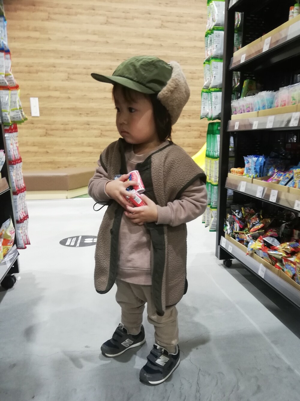 ブラウン系のベスト、ブラウン系のスウェット、ブルー系のスニーカーを着用したキッズの冬コーディネートの2枚目の写真