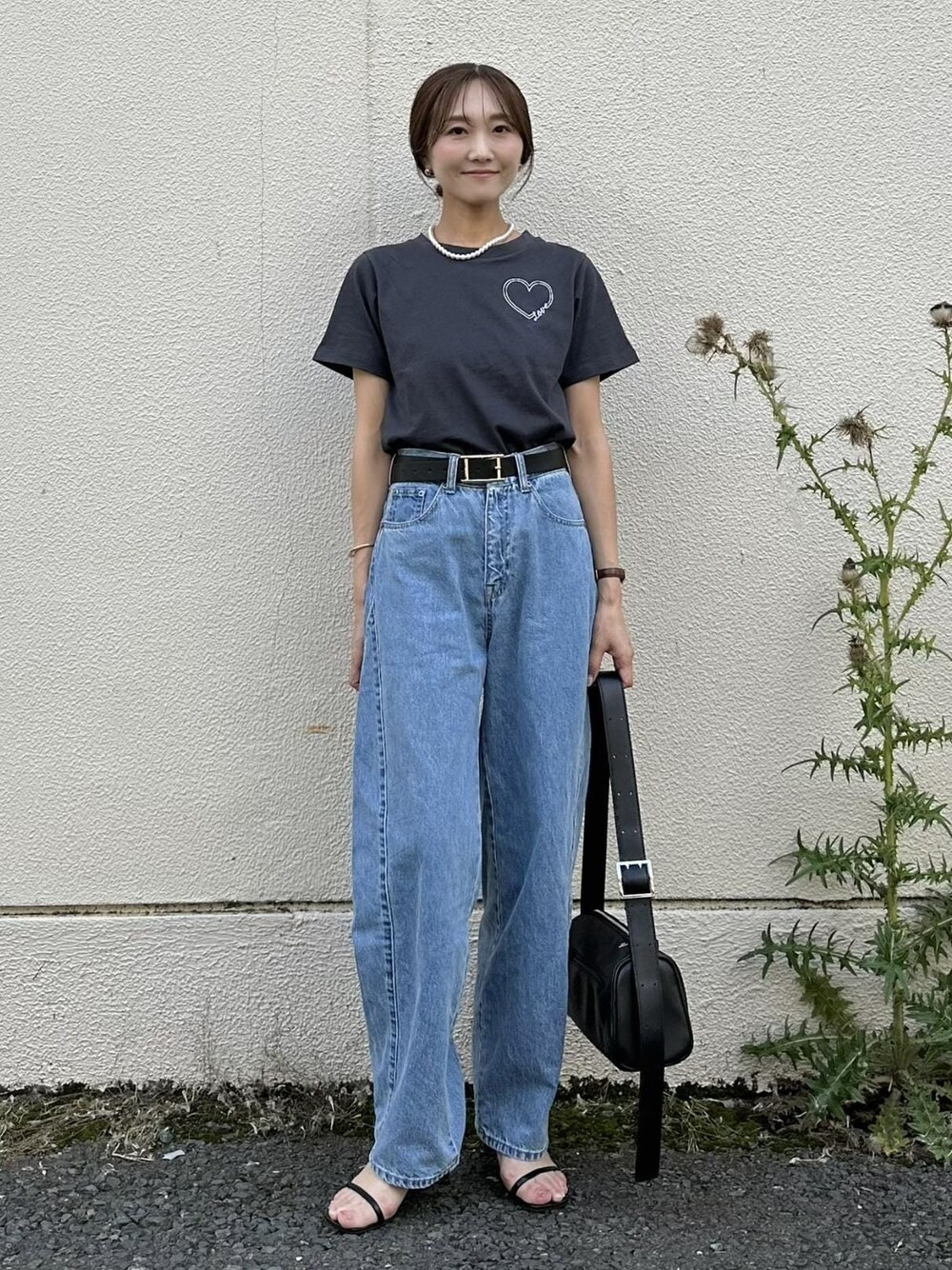 ブラック系のショルダーバッグ、ブルー系のデニムパンツ、ブラック系のTシャツ/カットソーを着用したレディースの夏コーディネートの1枚目の写真