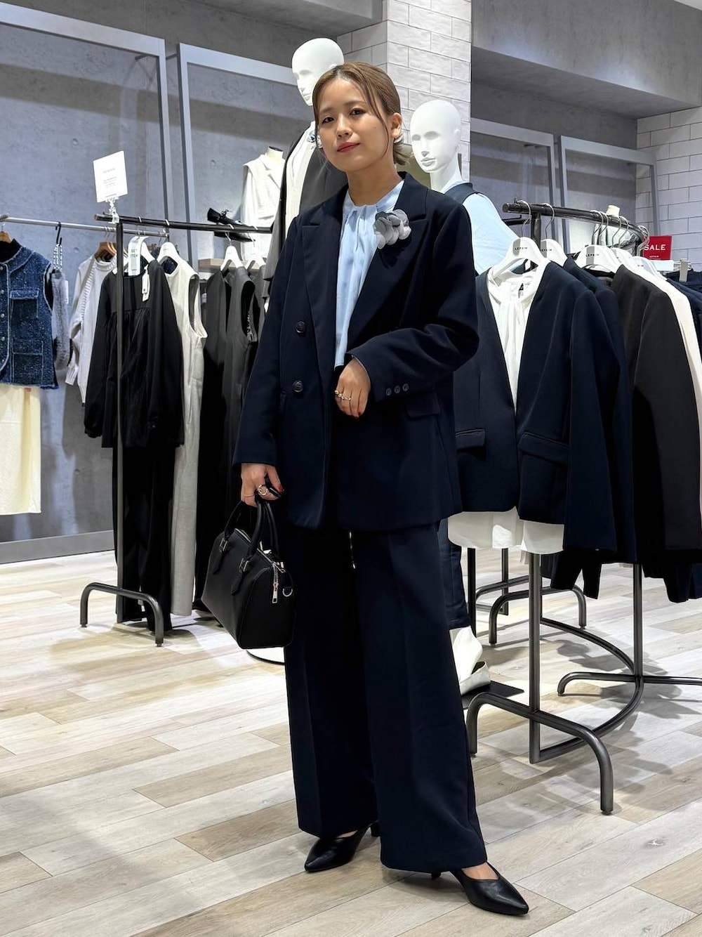 ブルー系のスーツパンツ、ブルー系のシャツ/ブラウス、ブラック系のパンプスを着用したレディースの冬コーディネートの1枚目の写真