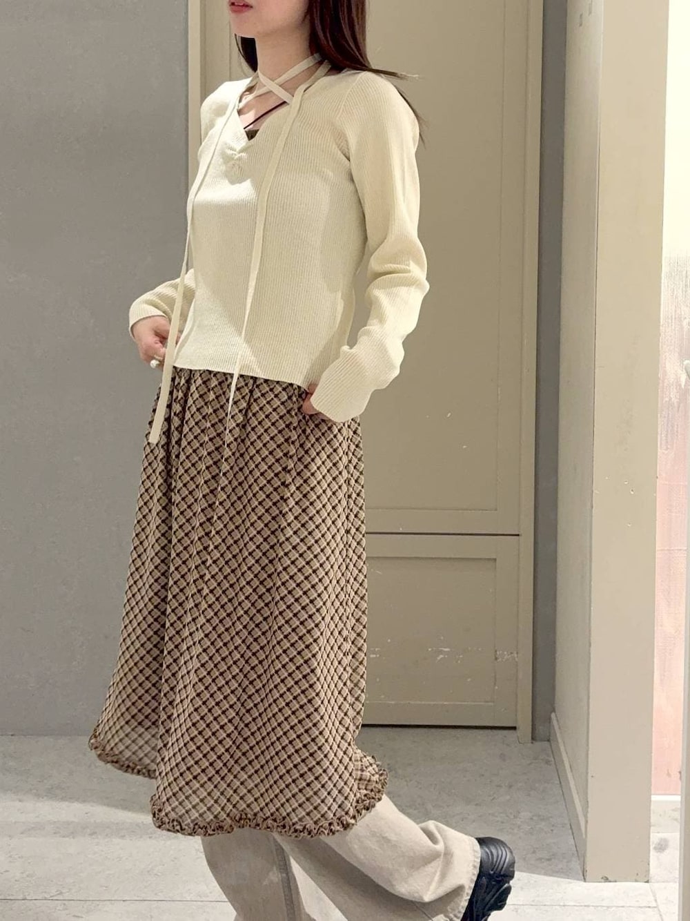 ベージュ系のデニムパンツ、ブラウン系のローファー、ホワイト系のニット/セーターを着用したレディースの冬コーディネートの1枚目の写真