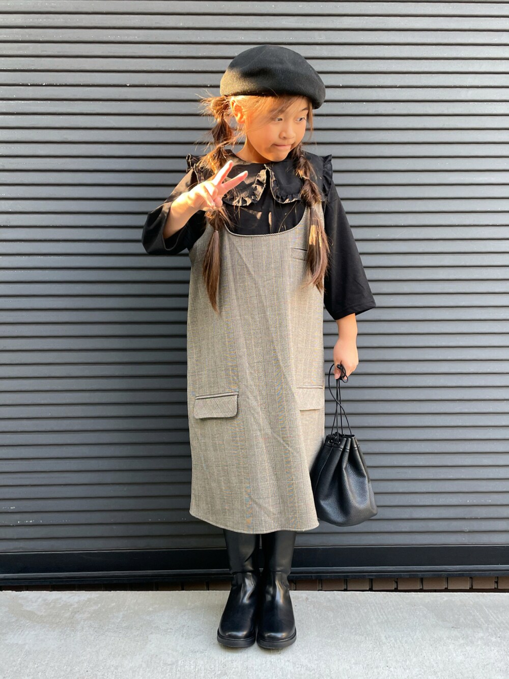 ブラック系のTシャツ/カットソー、ブラウン系のワンピース/ドレス、ブラック系のハンドバッグを着用したキッズの秋コーディネートの1枚目の写真