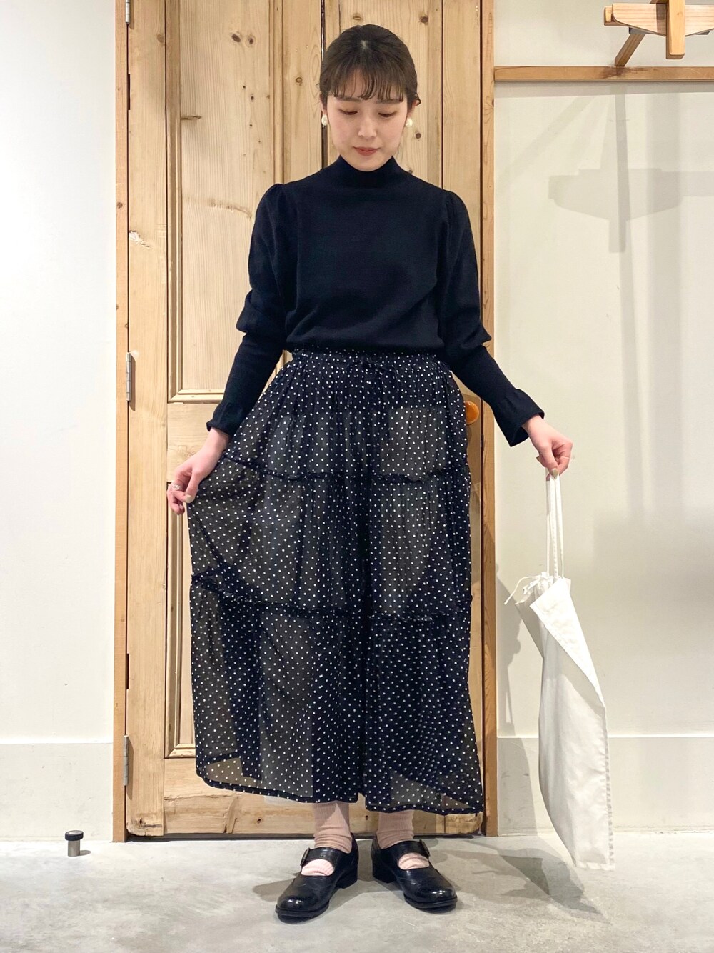 ブラック系のニット/セーター、ブラック系のスカート、ホワイト系のその他パンツを着用したレディースの冬コーディネートの1枚目の写真