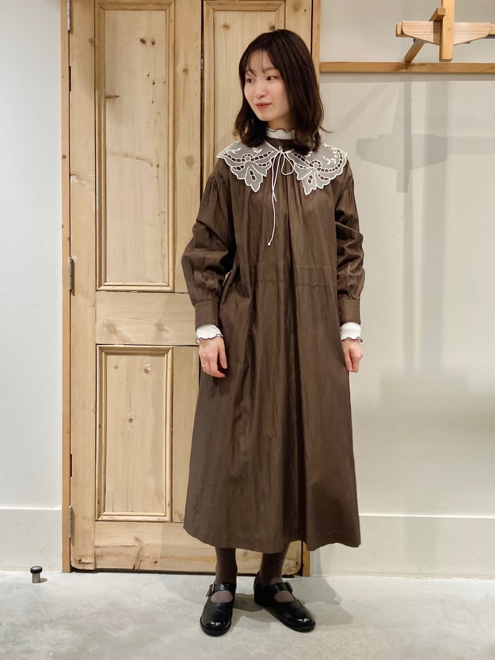 ブラウン系のワンピース、ホワイト系のTシャツ/カットソー、ブラック系のシューズを着用したレディースの冬コーディネートの1枚目の写真