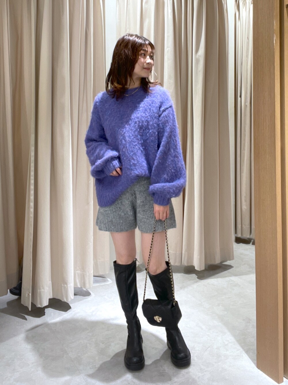 ブルー系のニット/セーター、グレー系のその他パンツ、ブラック系のブーツを着用したレディースの冬コーディネートの1枚目の写真