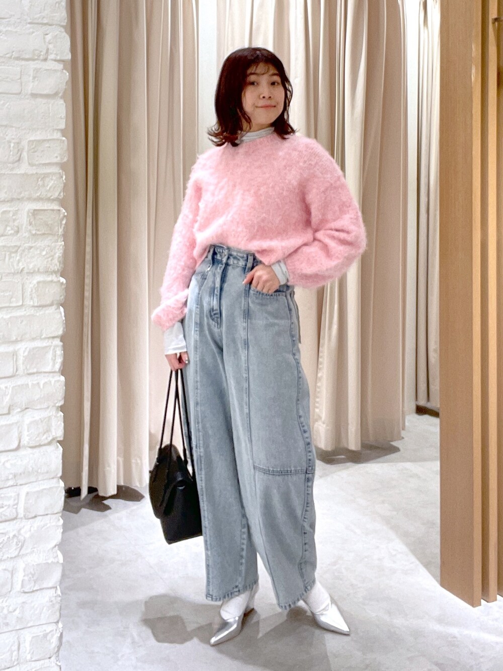 ブルー系のデニムパンツ、ブラック系のショルダーバッグ、シルバー系のパンプスを着用したレディースの冬コーディネートの1枚目の写真