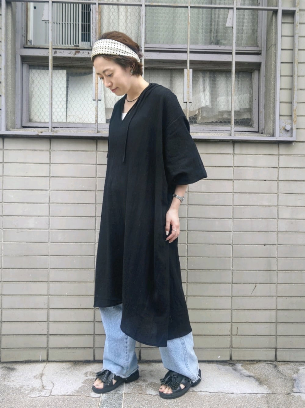 ブラック系のワンピース、ブラック系のサンダル、ホワイト系のヘアバンドを着用したレディースの夏コーディネートの1枚目の写真
