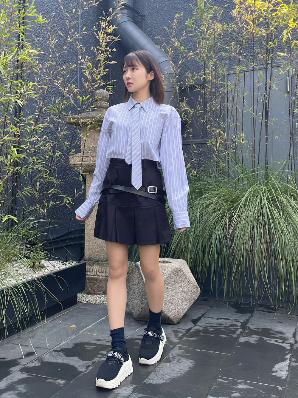 ブルー系のシャツ/ブラウス、ブラック系のスカートを着用したレディースの春コーディネートの1枚目の写真