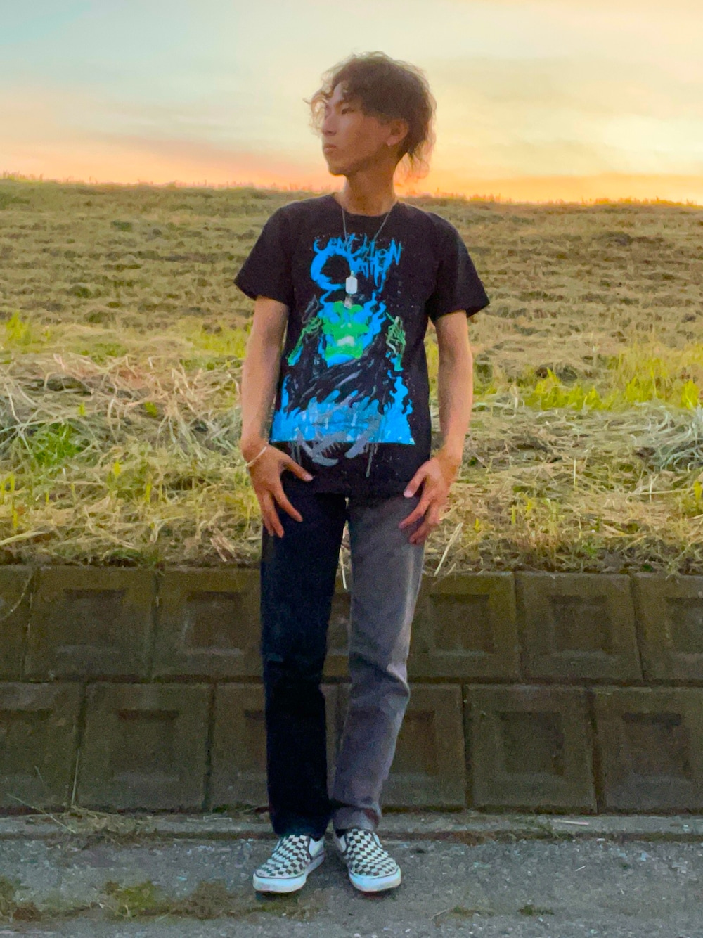 ブラック系のTシャツ/カットソー、ブラック系のデニムパンツ、ホワイト系のスニーカーを着用したメンズの秋コーディネートの1枚目の写真