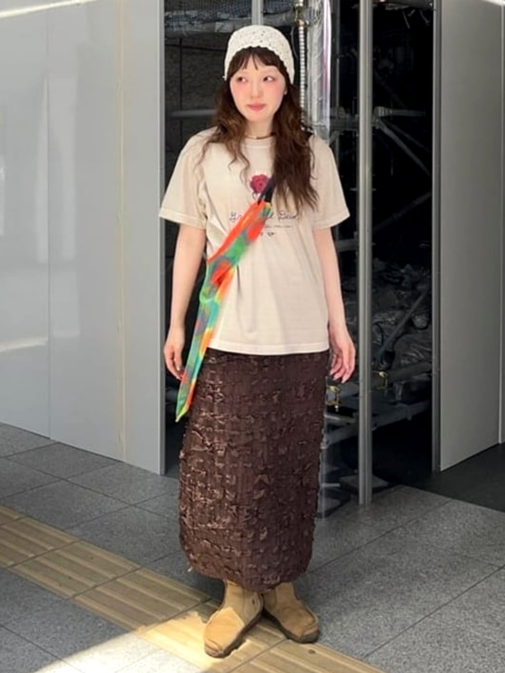 オレンジ系のトートバッグを着用したレディースの夏コーディネートの1枚目の写真
