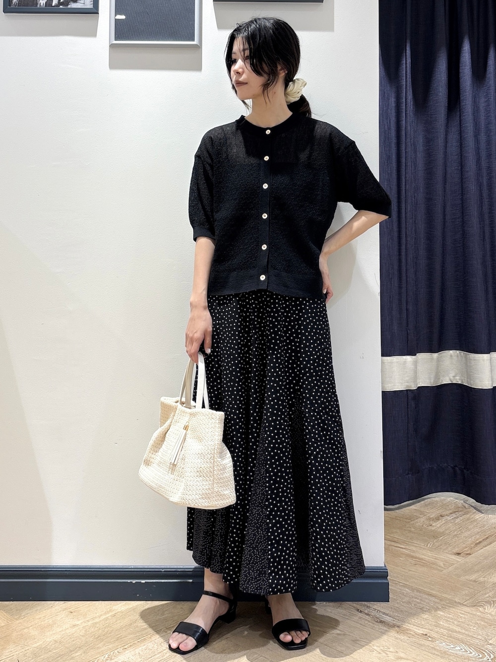 ブラック系のカーディガン/ボレロ、ブラック系のスカート、ホワイト系のトートバッグを着用したレディースの夏コーディネートの1枚目の写真