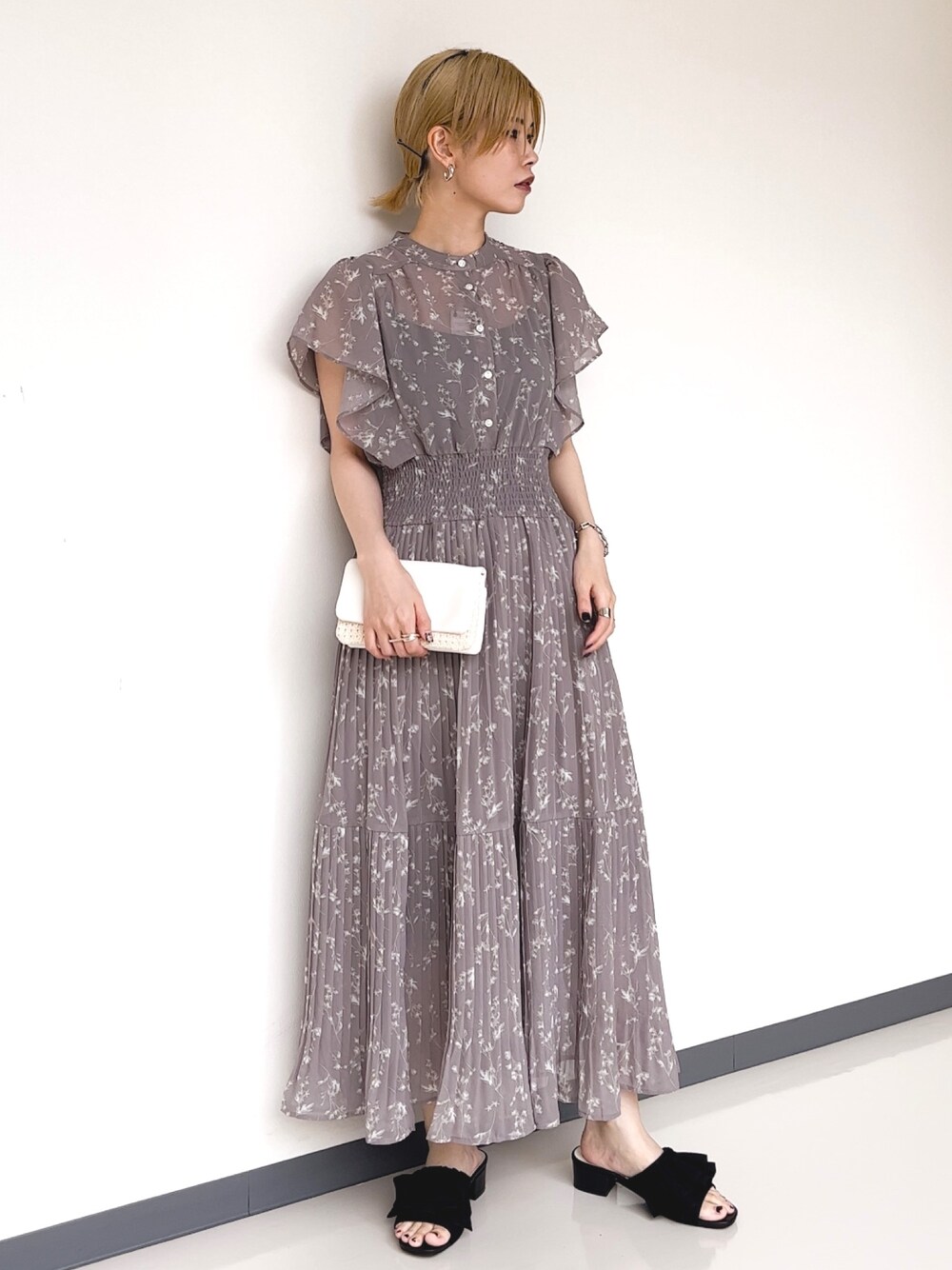 ベージュ系のワンピース、ベージュ系のショルダーバッグ、ブラック系のサンダルを着用したレディースの夏コーディネートの1枚目の写真