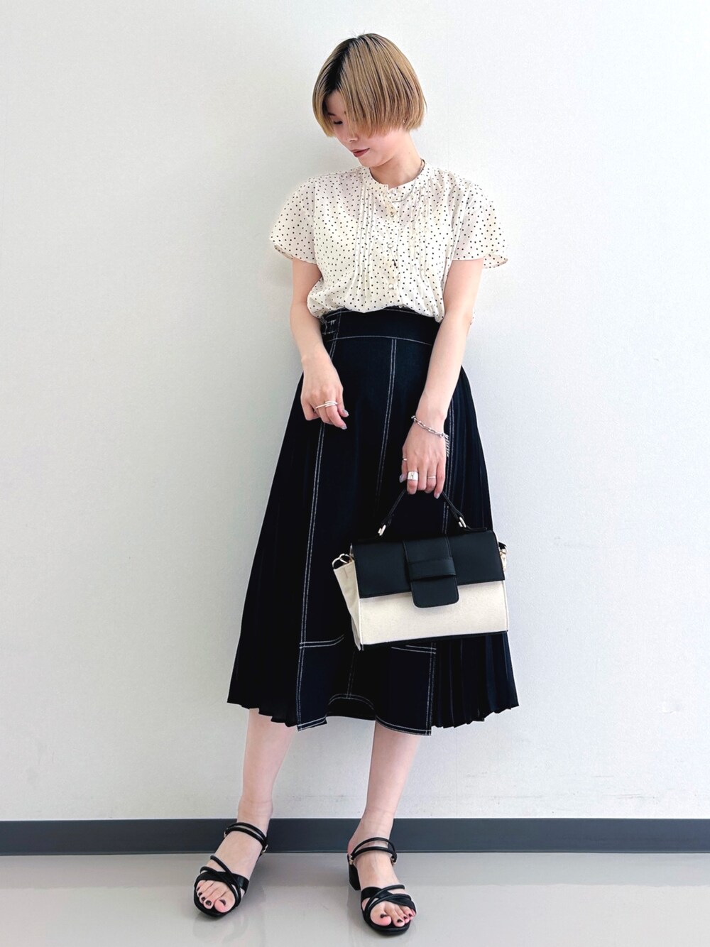 ベージュ系のシャツ/ブラウス、ブルー系のスカート、ブラック系のショルダーバッグを着用したレディースの春コーディネートの1枚目の写真